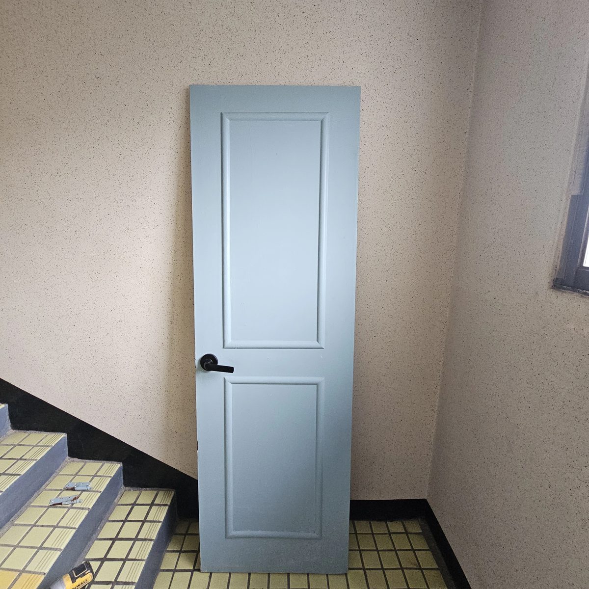 새 문짝 세워 설치하는 사진